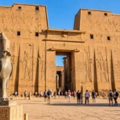 Great pylon of Edfu Temple with the granite falcon statue of Horus in front