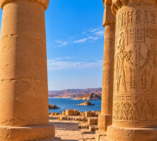 Plain unfinished column of Maharraqa beside a carved hieroglyphic column at a neighboring temple